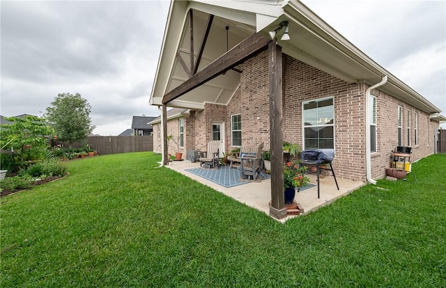rear view of property with a lawn, a fenced backyard, and brick siding