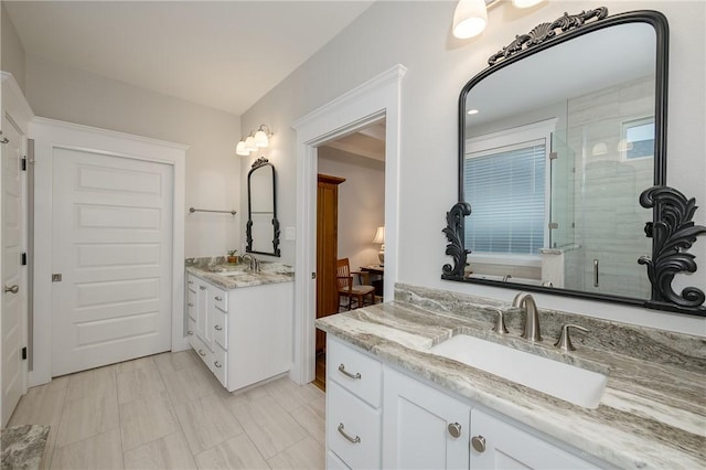 bathroom with a sink, two vanities, and a shower stall