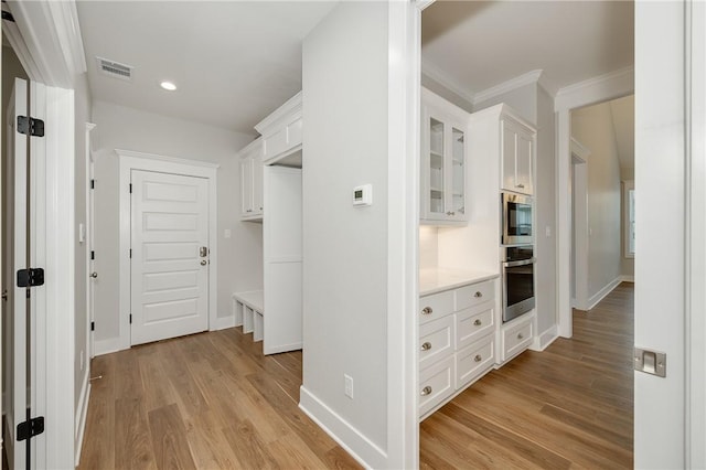 5012 Grayson Way, Bryan, TX 77802 - hallway with light wood-type flooring, ornamental molding, and recessed lighting