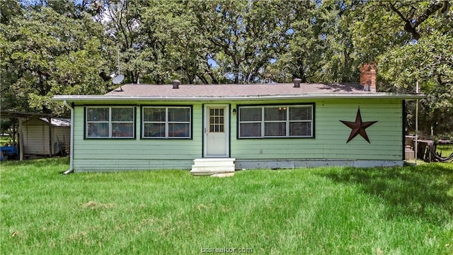 view of front of house featuring a front yard and a storage unit