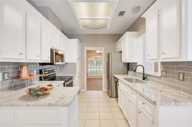 4213 Bedford Ct, Bryan, TX 77802 - kitchen with appliances with stainless steel finishes, light tile patterned flooring, white cabinetry, decorative backsplash, and light stone counters