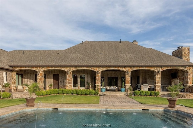 rear view of property featuring a patio, pool water feature, and a lawn