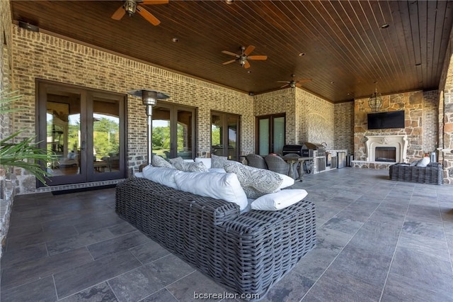 view of patio with an outdoor stone fireplace, an outdoor kitchen, and french doors