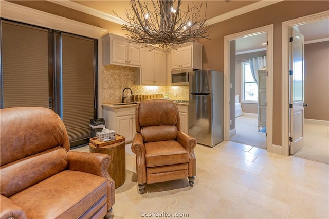 sitting room with a notable chandelier, crown molding, and sink