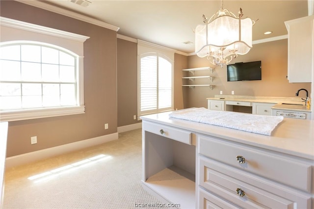 kitchen with light carpet, pendant lighting, white cabinetry, and sink