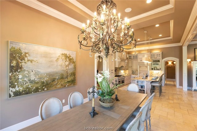 dining room with a raised ceiling, ornamental molding, and a notable chandelier