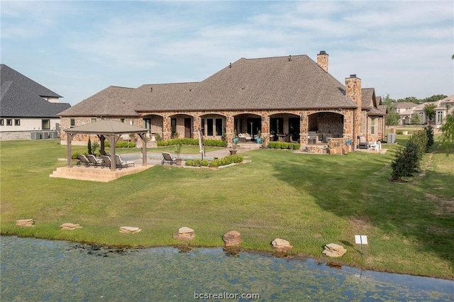 back of house featuring a gazebo, a yard, a water view, and a patio