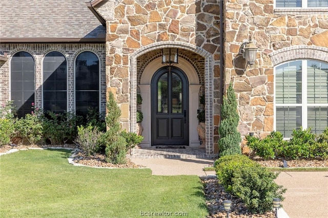 view of exterior entry with a lawn