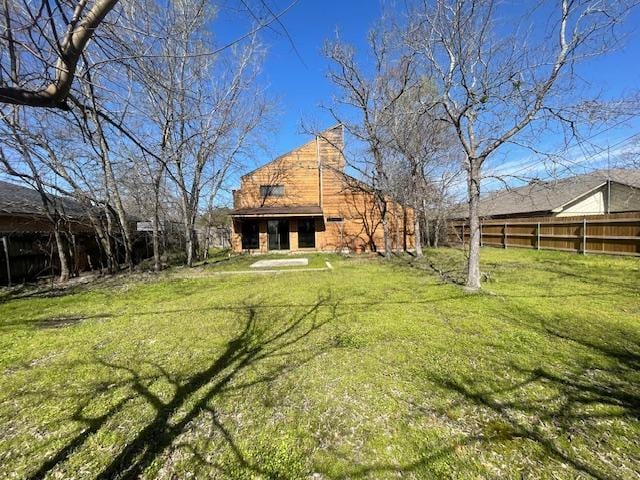 view of yard with a barn, an outdoor structure, and fence