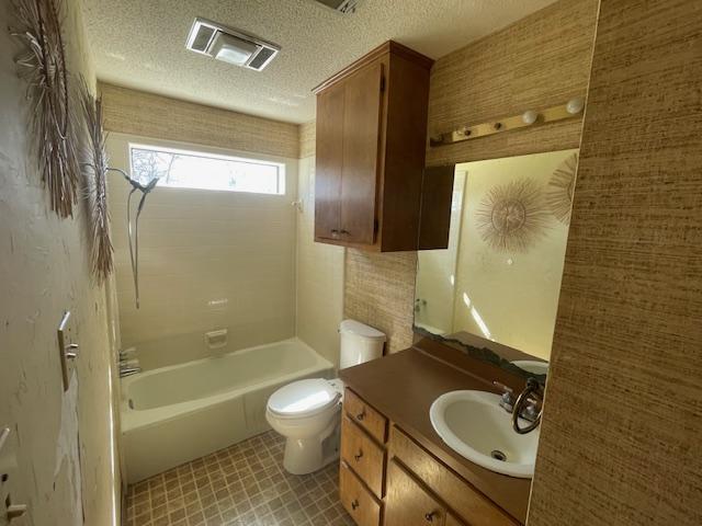 full bath featuring tile patterned floors, visible vents, toilet, a textured ceiling, and vanity