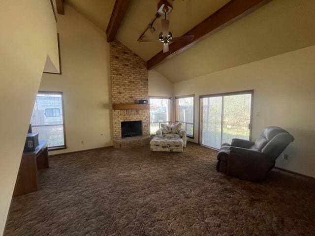 unfurnished living room featuring carpet flooring, beamed ceiling, a brick fireplace, and a ceiling fan