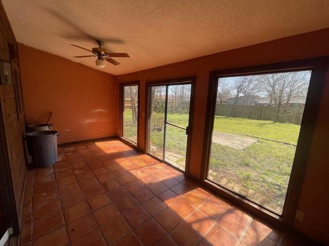 unfurnished sunroom featuring lofted ceiling and a ceiling fan