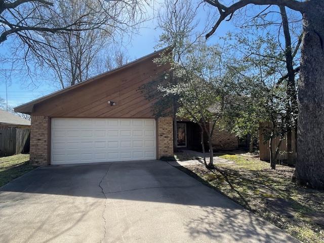 view of front of home with brick siding, driveway, and an attached garage