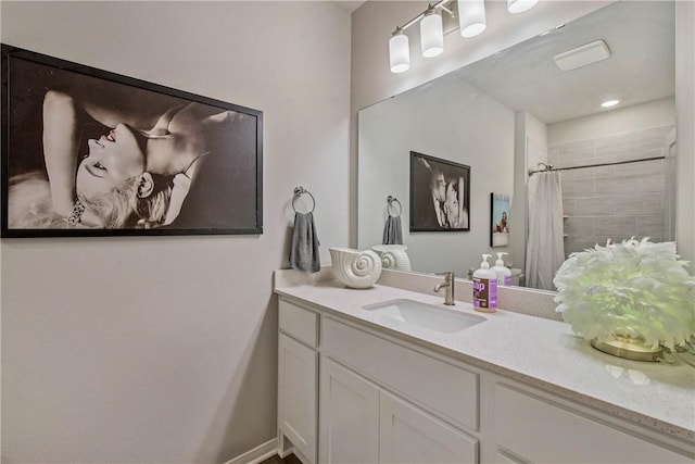 full bath featuring curtained shower, vanity, and baseboards