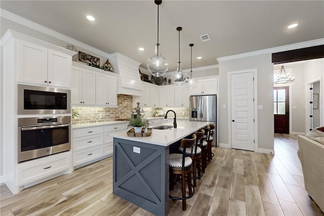 kitchen featuring sink, white cabinetry, backsplash, pendant lighting, and appliances with stainless steel finishes