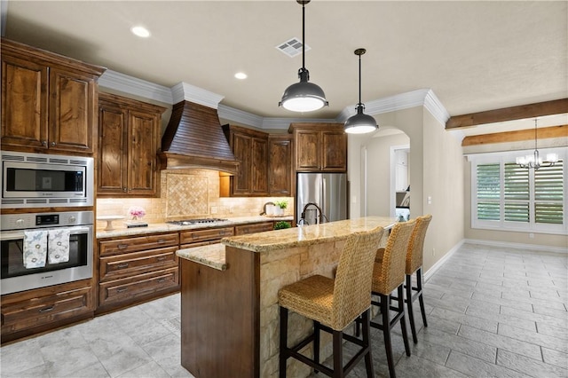 5104 Stonewater Loop, College Station, TX 77845 - kitchen with stainless steel appliances, premium range hood, tasteful backsplash, light stone counters, and a kitchen breakfast bar