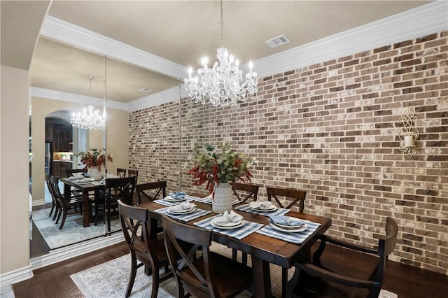 5104 Stonewater Loop, College Station, TX 77845 - dining area with a chandelier, arched walkways, wood finished floors, brick wall, and crown molding