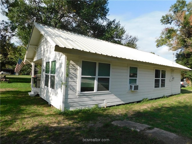 1117 Sycamore St, Navasota, TX 77868 - view of side of home featuring a yard, metal roof, cooling unit, and entry steps