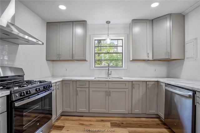 kitchen featuring gray cabinets, sink, wall chimney range hood, and appliances with stainless steel finishes