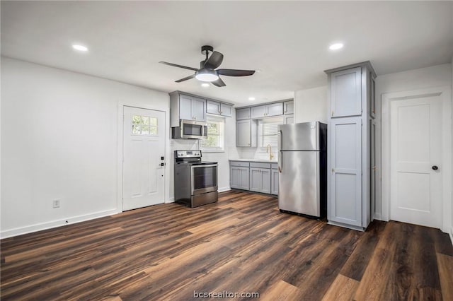 kitchen featuring dark wood-type flooring, sink, ceiling fan, gray cabinets, and stainless steel appliances