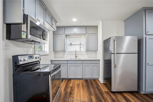 kitchen with gray cabinetry, dark hardwood / wood-style flooring, sink, and stainless steel appliances