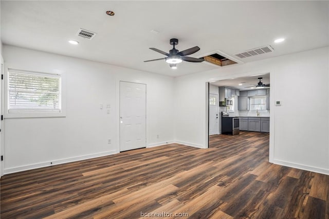 unfurnished living room featuring ceiling fan, dark wood-type flooring, and sink