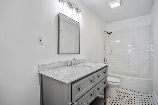 full bathroom featuring vanity, tiled shower / bath combo, toilet, and tile patterned flooring