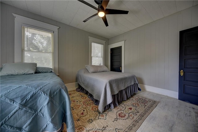 803 Holland St, Navasota, TX 77868 - bedroom featuring light hardwood / wood-style floors, ceiling fan, and wood walls