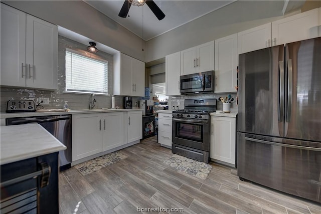 803 Holland St, Navasota, TX 77868 - kitchen with decorative backsplash, stainless steel appliances, white cabinetry, and light hardwood / wood-style flooring