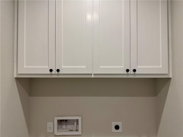 laundry room with electric dryer hookup, hookup for a washing machine, and cabinets