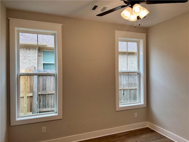 unfurnished room featuring dark wood-type flooring, plenty of natural light, and ceiling fan