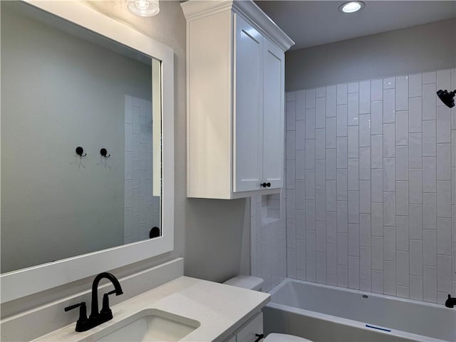 full bathroom with vanity, tiled shower / bath, and toilet