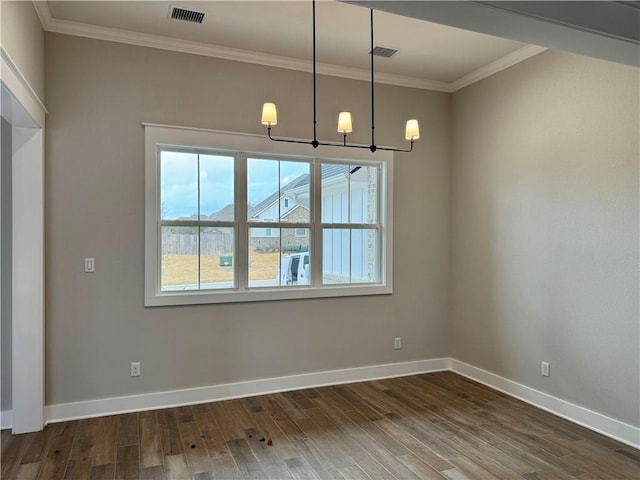 unfurnished dining area with dark hardwood / wood-style flooring, ornamental molding, and an inviting chandelier