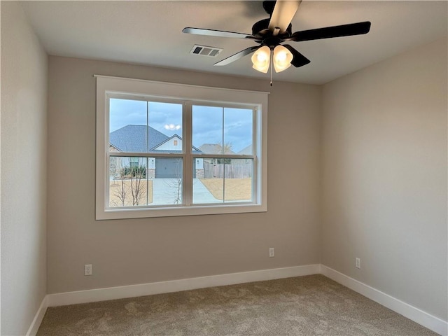 carpeted spare room featuring ceiling fan