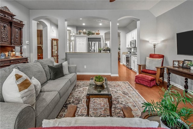 living room featuring vaulted ceiling and light hardwood / wood-style flooring