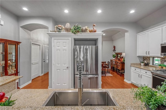 kitchen featuring white cabinetry, appliances with stainless steel finishes, light hardwood / wood-style floors, and sink