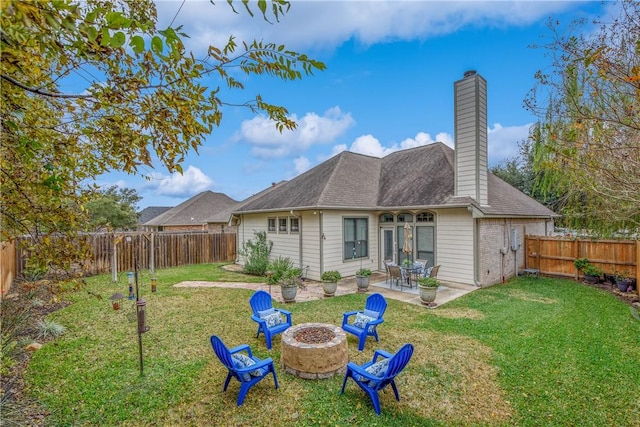 back of property with an outdoor fire pit, a patio, and a lawn