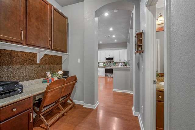 interior space with built in desk and light hardwood / wood-style floors