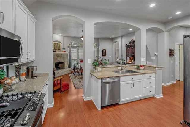 kitchen with white cabinetry, sink, light hardwood / wood-style flooring, and appliances with stainless steel finishes