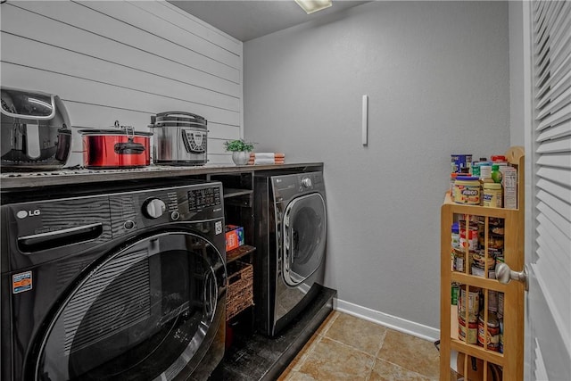 laundry area with washer and dryer and wood walls