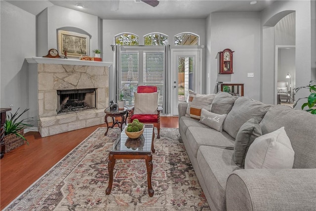 living room featuring hardwood / wood-style floors, a fireplace, and ceiling fan