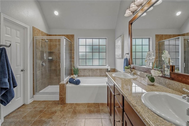 bathroom with vanity, tile patterned flooring, vaulted ceiling, and independent shower and bath