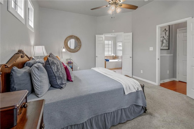 carpeted bedroom with multiple windows, ensuite bath, and ceiling fan