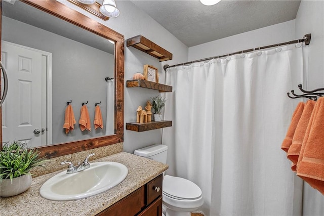 bathroom with vanity, toilet, a shower with shower curtain, and a textured ceiling