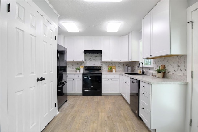 407 N Amthor St, Bellville, TX 77418 - kitchen with sink, range hood, black appliances, white cabinets, and light wood-type flooring