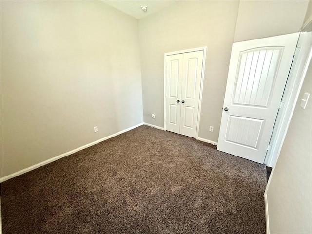 4704 Los Pines Way, Bryan, TX 77807 - unfurnished bedroom featuring dark colored carpet, baseboards, and a closet
