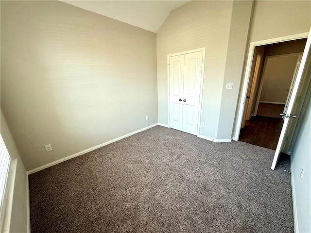 4704 Los Pines Way, Bryan, TX 77807 - unfurnished bedroom with vaulted ceiling, dark carpet, baseboards, and a closet