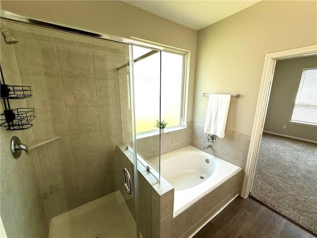 4704 Los Pines Way, Bryan, TX 77807 - bathroom with a stall shower, healthy amount of natural light, a bath, and wood finished floors