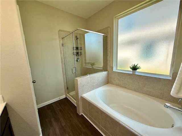 4704 Los Pines Way, Bryan, TX 77807 - bathroom with a shower stall, a bath, wood finished floors, and baseboards