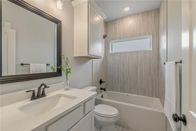 full bathroom with toilet, vanity, and tiled shower / bath